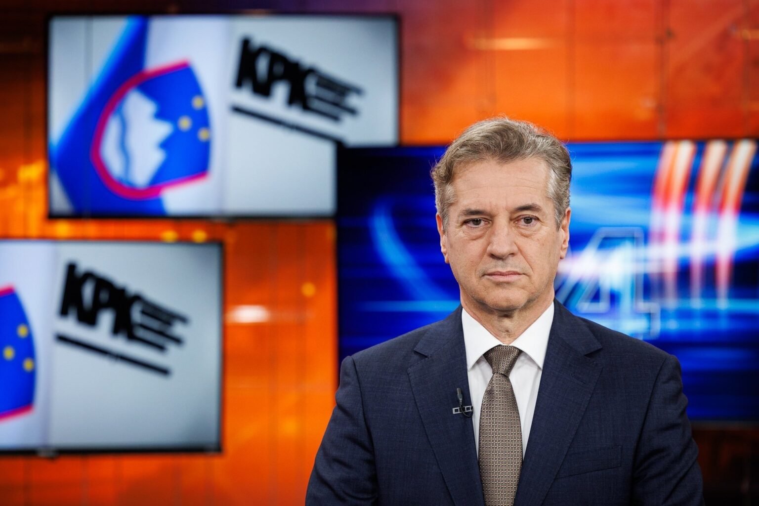 Премьер-министр Словении Роберт Голоб в студии POP TV на фоне логотипов KPK (Комиссии по предотвращению коррупции). Роберт Голоб, премьер-министр Словении