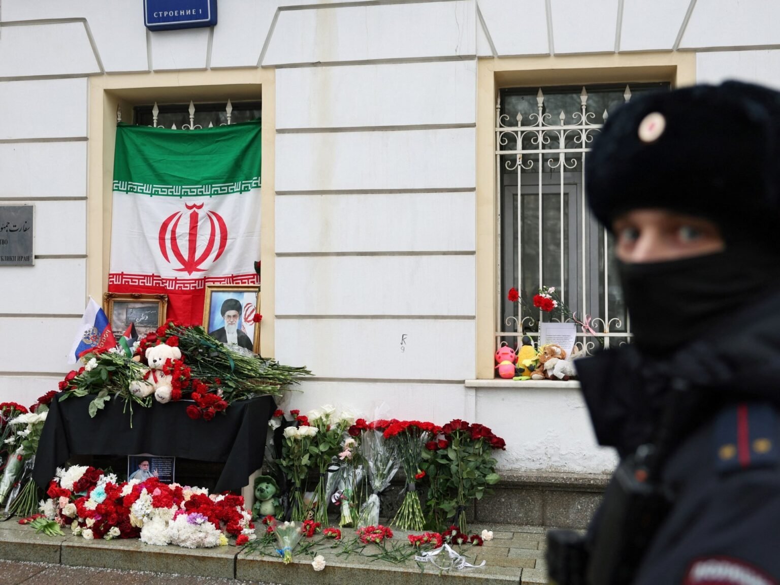 Мемориал у посольства Ирана в Москве: цветы, портреты и иранский флаг на фоне полицейского оцепления