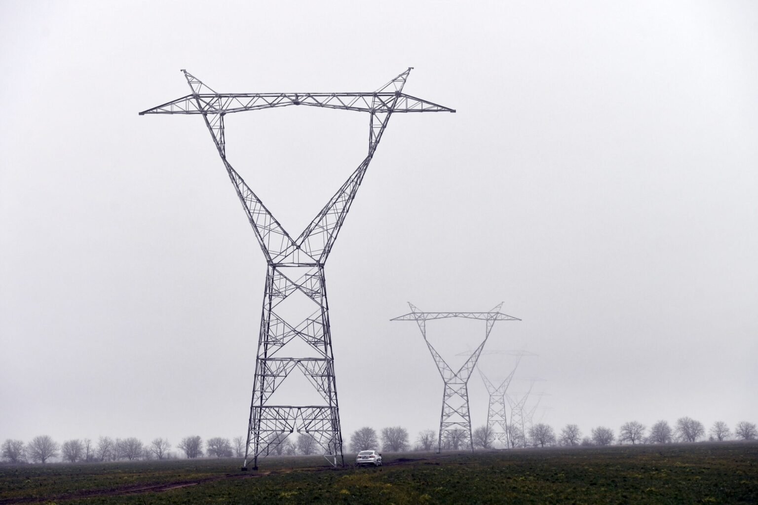 Опоры высоковольтных линий электропередач в туманном поле Молдовы