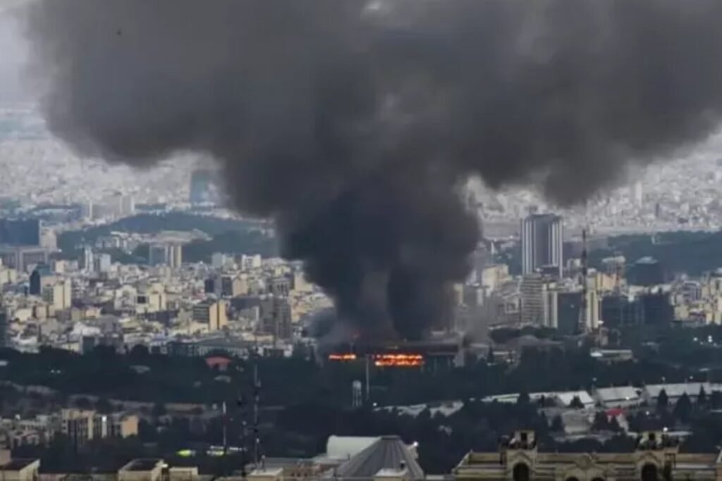 Тебриз под ударами: журналист рассказал о жизни без сирен и укрытий Столб чёрного дыма поднимается над Тебризом после авиаударов — вид на городскую застройку днём