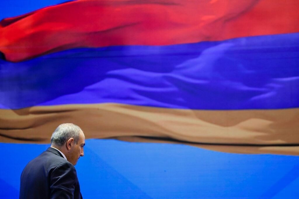 Выборы в Армении: расколотая оппозиция и шантаж войной Силуэт человека на фоне армянского триколора — символ предстоящих парламентских выборов в Армении