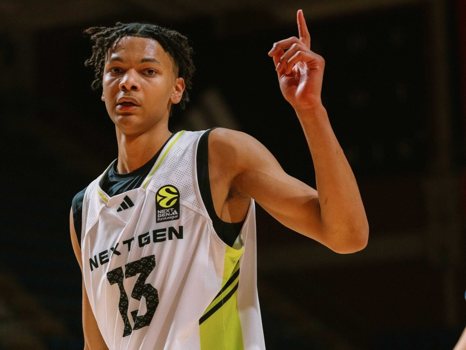 Молодой баскетболист в форме NextGen указывает вверх после удачного действия на турнире NextGen Евролиги в Белграде