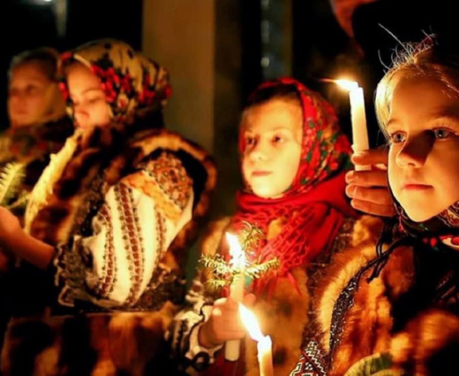 Дети в традиционных буковинских костюмах держат пасхальные свечи во время празднования в Буковине