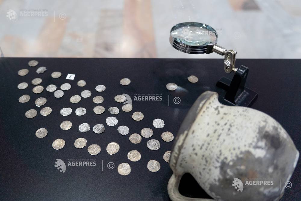 Клад Мирчи Старого — серебряные монеты XIV века, разложенные на музейном стенде рядом с керамическим сосудом и увеличительным стеклом