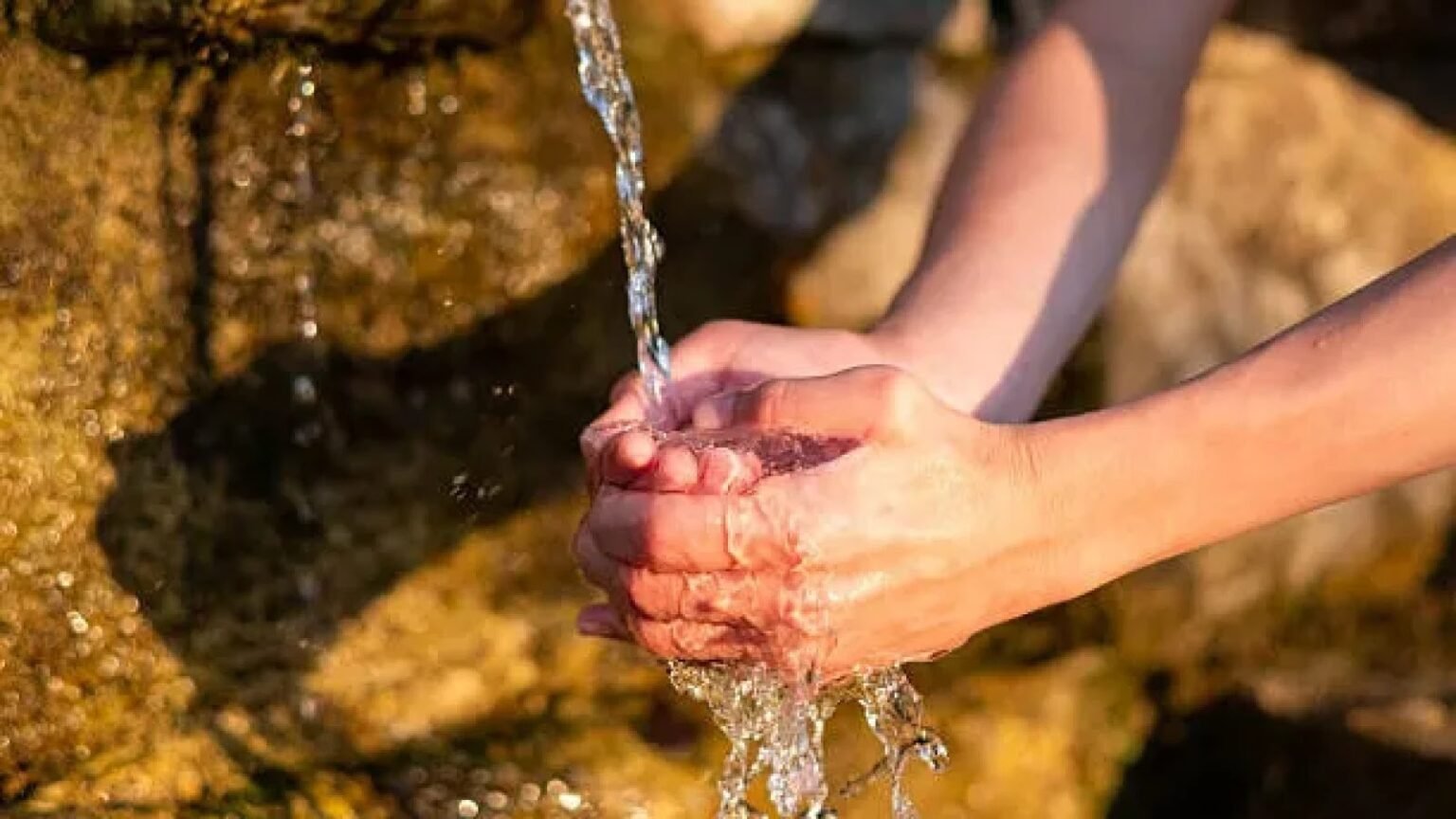 Жительница набирает воду из природного горного родника