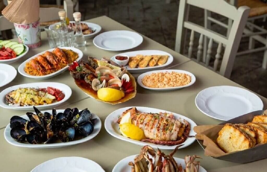 Ципурадика Волоса: традиция, которую забыли продвигать Традиционные закуски и морепродукты на столе в ципурадико — мидии, креветки, рыба и салаты по-гречески