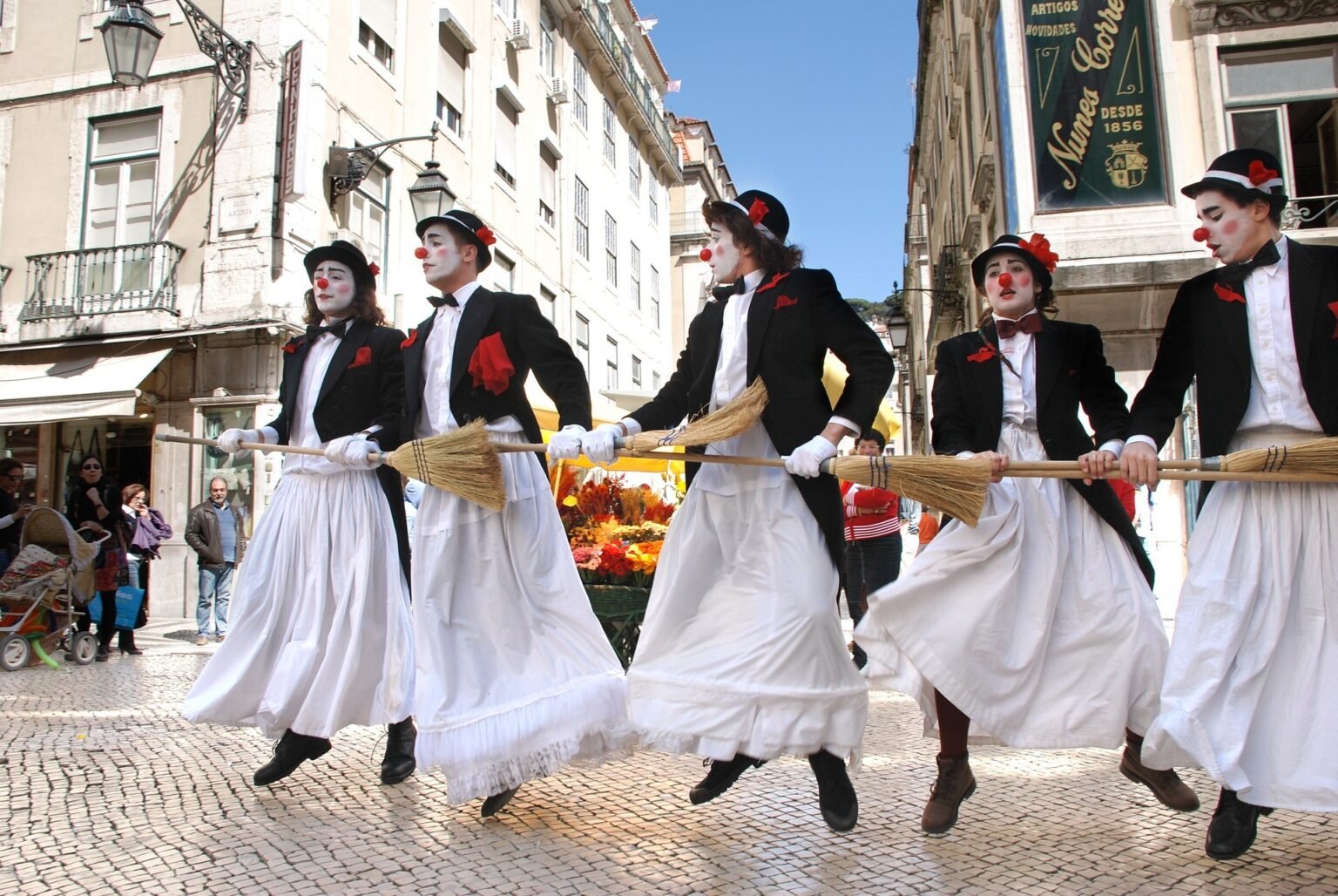 Армянская диаспора отмечает Международный день театра Уличные артисты в костюмах клоунов танцуют с мётлами на празднике Международного дня театра в европейском городе