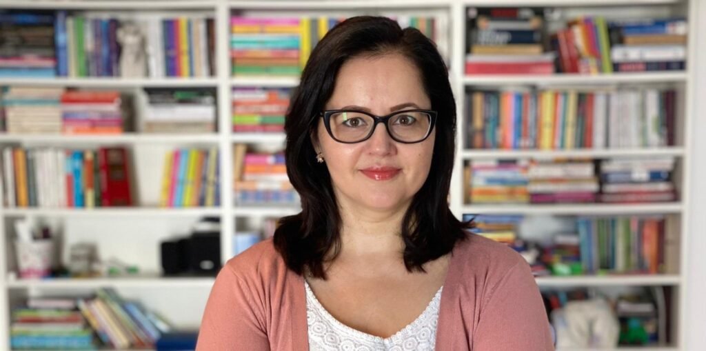 Психотерапевт Татьяна Морарь на фоне домашней библиотеки