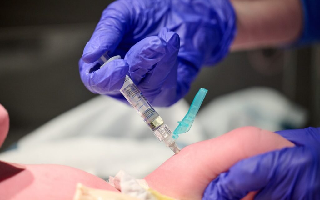 Витамин K и лейкемия: почему конспирология угрожает младенцам Медицинский работник делает инъекцию витамина K новорождённому в больнице