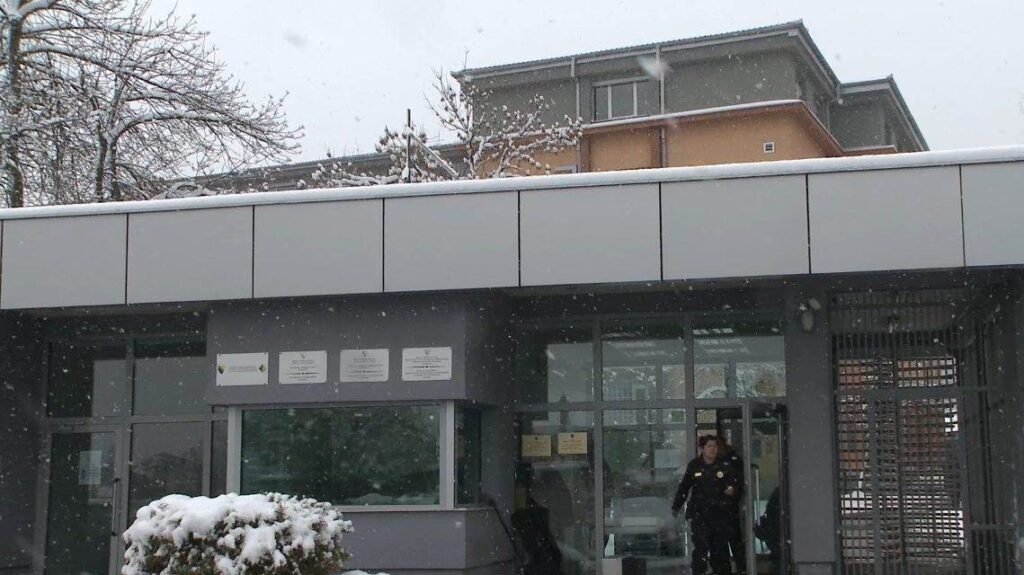 Здание Суда Боснии и Герцеговины в Сараево зимой, у входа стоит охранник