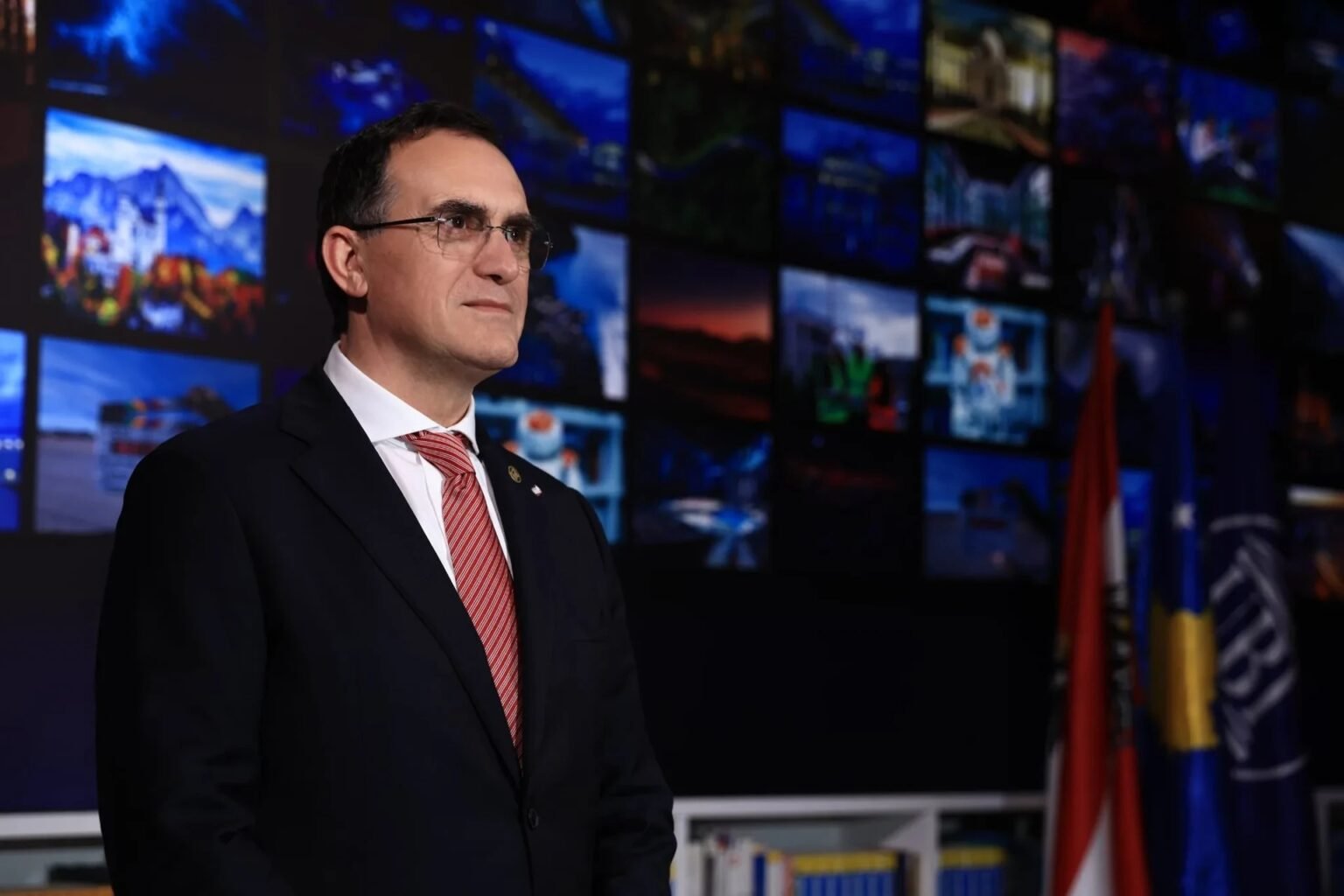 Эдмонд Хайризи, новоназначенный вице-президент Европейской организации качества, на фоне мультимедийного экрана