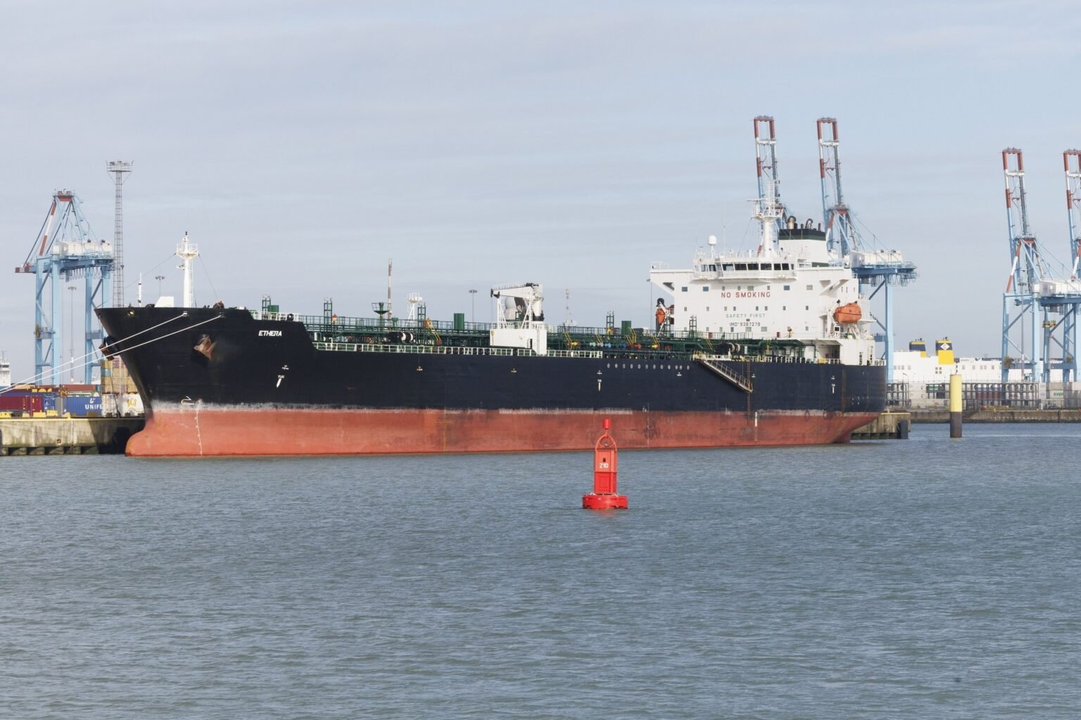 Танкер Ethera пришвартован в порту днём, чётко видно судно с надписью 'NO SMOKING' на надстройке. Фото: Belga News Agency