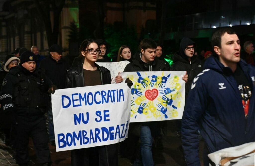 Впервые в Гагаузии: марш мира в поддержку Украины в Комрате Ночной протест с участниками, держащими плакаты «Демократия не бомбится» на румынском языке и символы мира в украинских цветах