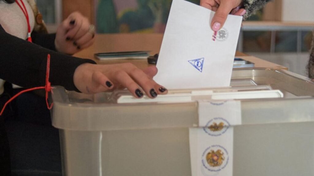 Выборы в Армении: кто давит на избирателей Голосование на избирательном участке в Армении: избирательница опускает бюллетень в урну с государственной печатью