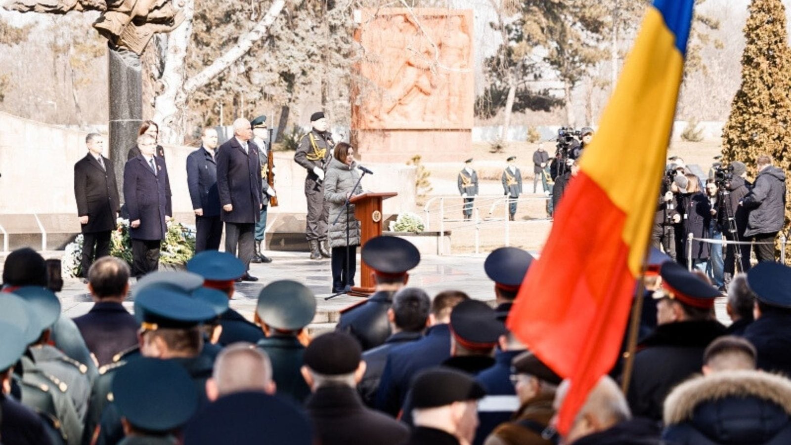 Общий план церемонии с молдавским флагом, военнослужащими в зале, Санду на трибуне с официальными лицами. Фото: Unknown