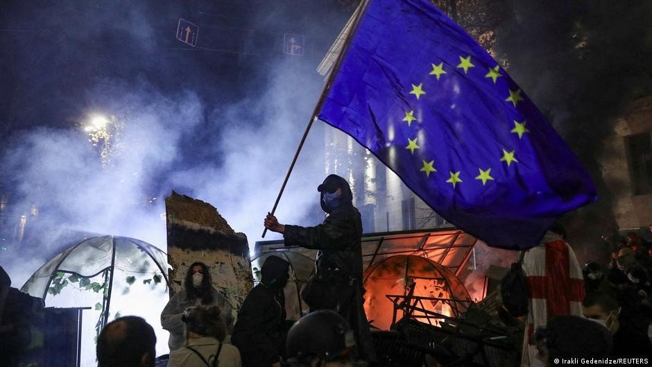 Протестующий с флагом ЕС в клубах слезоточивого газа во время акции в Тбилиси. Фото: Deutsche Welle