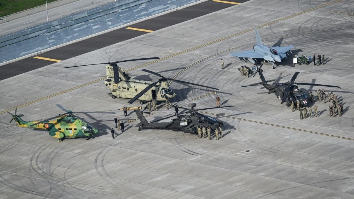 Военная техника НАТО на взлётной полосе румынской авиабазы: румынский вертолёт IAR 330, американский CH-47 Chinook, ударный AH-64 Apache и истребитель Eurofighter Typhoon