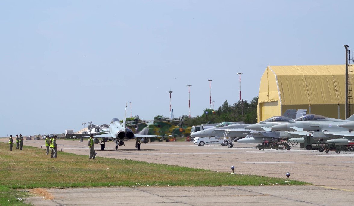 Истребители и военные вертолёты на взлётной полосе авиабазы Михаил Когэлничану в Румынии