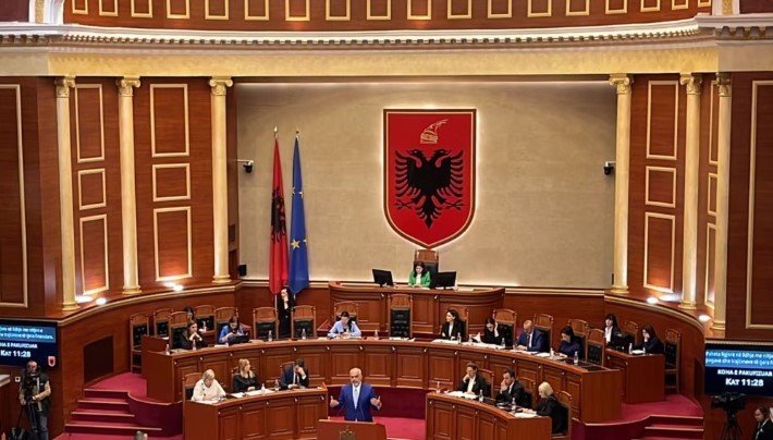 Заседание парламента Албании &mdash; депутаты в зале с государственным гербом и флагами Албании и ЕС