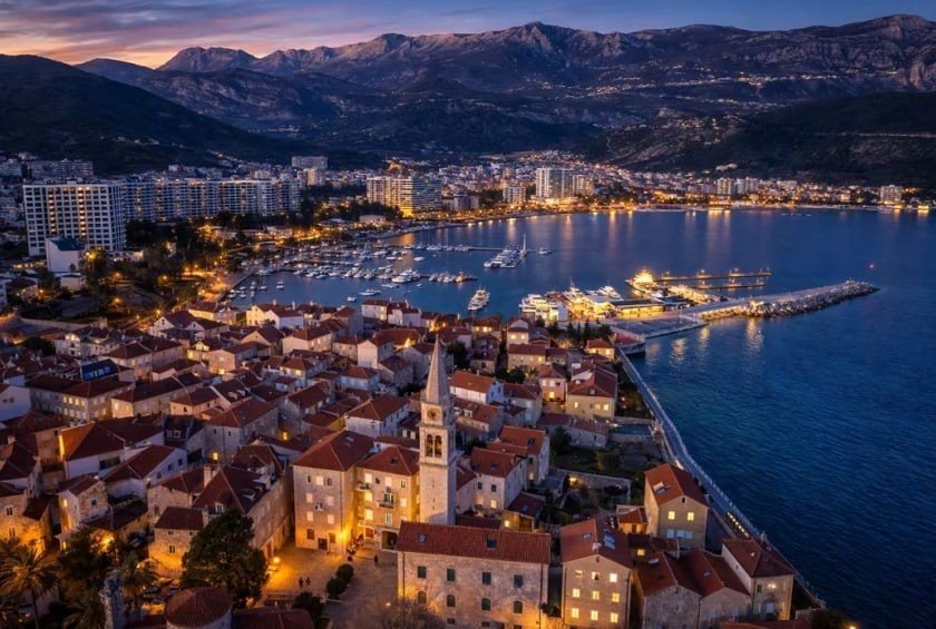 Вечерняя панорама Старого города Будвы с гаванью и горами на фоне — один из главных курортов Черногории