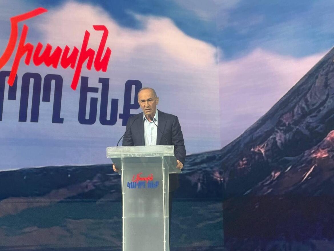 Роберт Кочарян выступает с речью на трибуне съезда блока «Айастан» на фоне горы Арарат и лозунгов предвыборной кампании