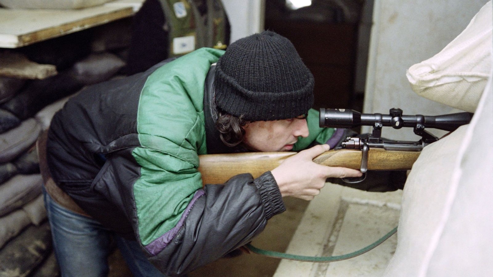 Снайпер целится из укреплённой позиции во время осады Сараево в 1990-х годах