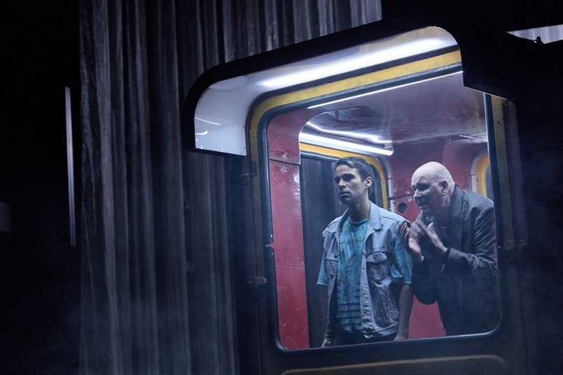 Сцена из спектакля «Радио Сараево» — два актёра в окне трамвайной декорации на тёмной сцене Ландестеатра Линца