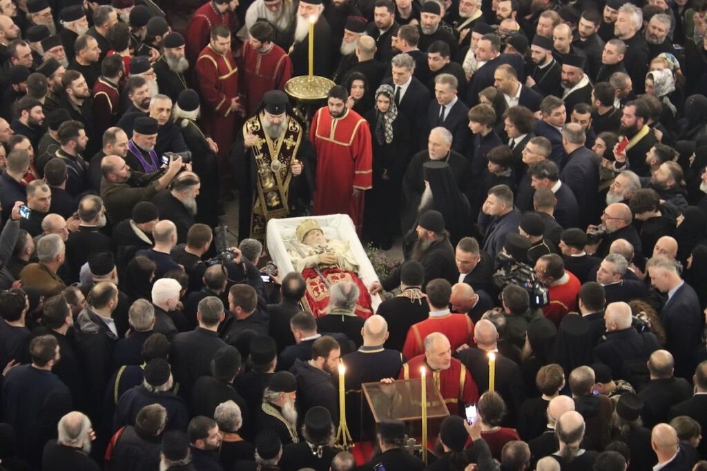 Траурная процессия с гробом Патриарха Илии II, вид сверху — духовенство в облачениях несёт гроб в окружении тысяч верующих и официальных лиц