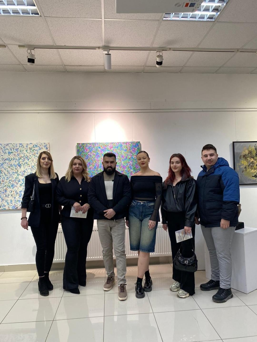 Участники выставки новопринятых членов ULUKiM на фоне работ в галерее Дома культуры в Зубин-Потоке