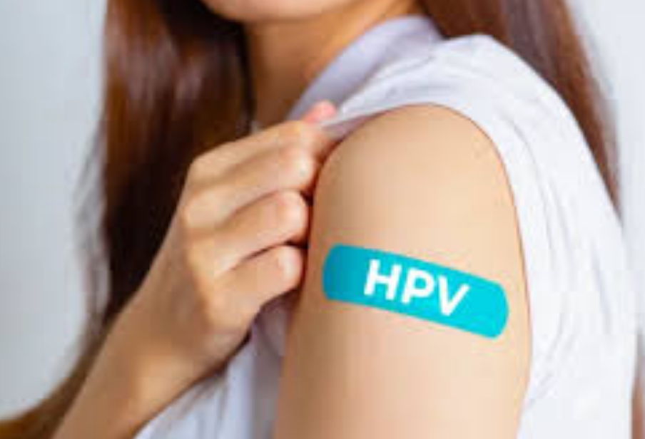 Молодая женщина демонстрирует пластырь с надписью HPV на плече после вакцинации