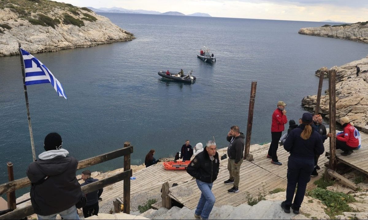 Поисково-спасательная операция у скалистого побережья Вулиагмени — спасатели на причале, катера береговой охраны и греческий флаг