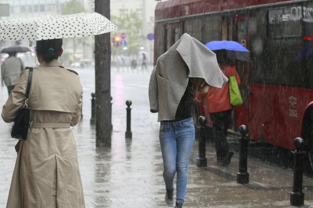 Прохожие под дождём на улице Белграда — затяжные осадки обрушились на столицу Сербии в конце марта
