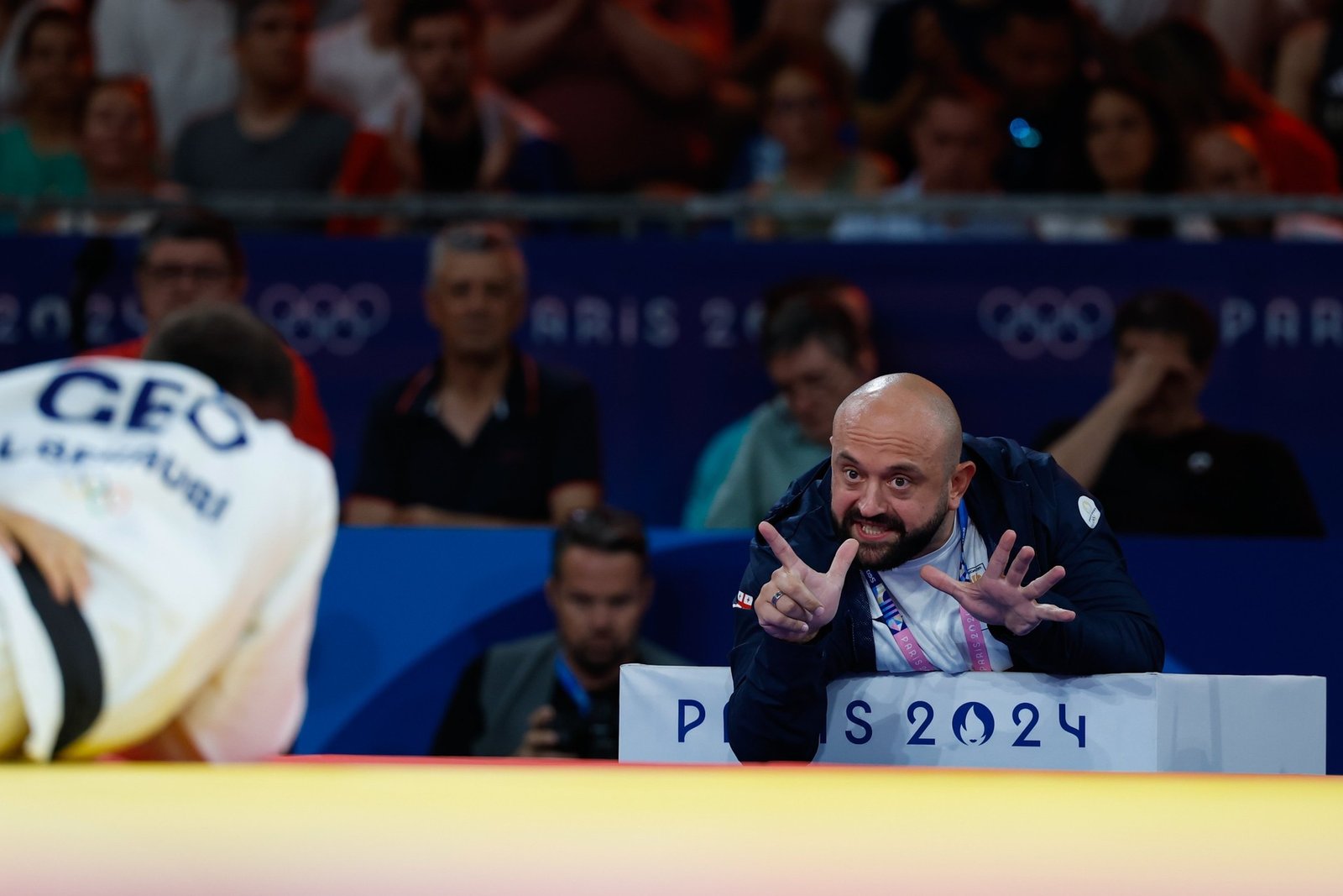 Лаша Гуджеджиани жестами подсказывает своему спортсмену во время поединка на Олимпийских играх в Париже 2024