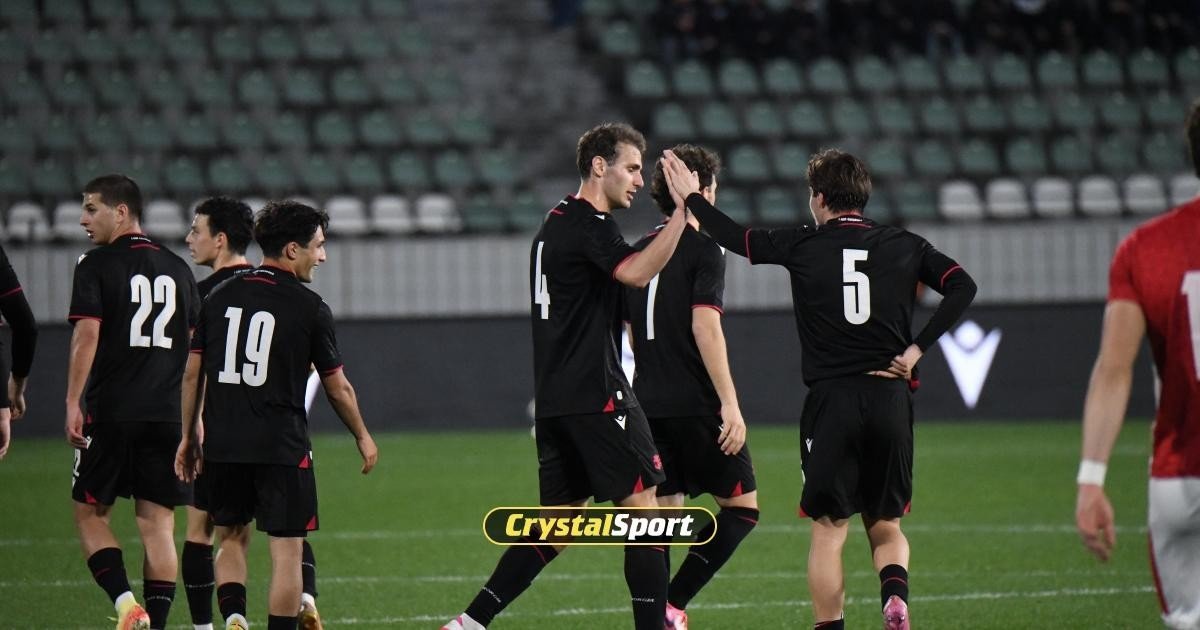 Грузинские футболисты в чёрной форме празднуют забитый мяч на стадионе