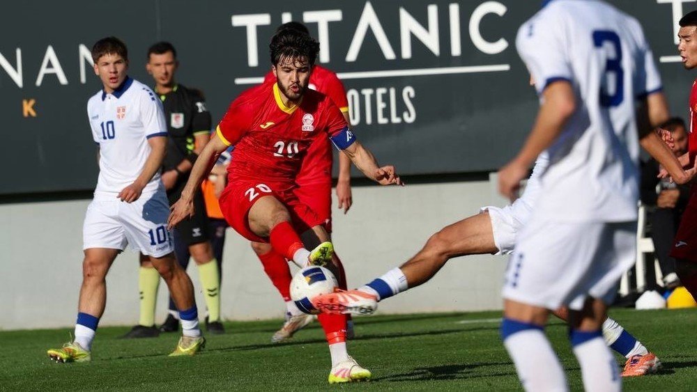Игрок сборной Кыргызстана (U-23) в борьбе за мяч с защитниками Сербии во время товарищеского матча в Анталии