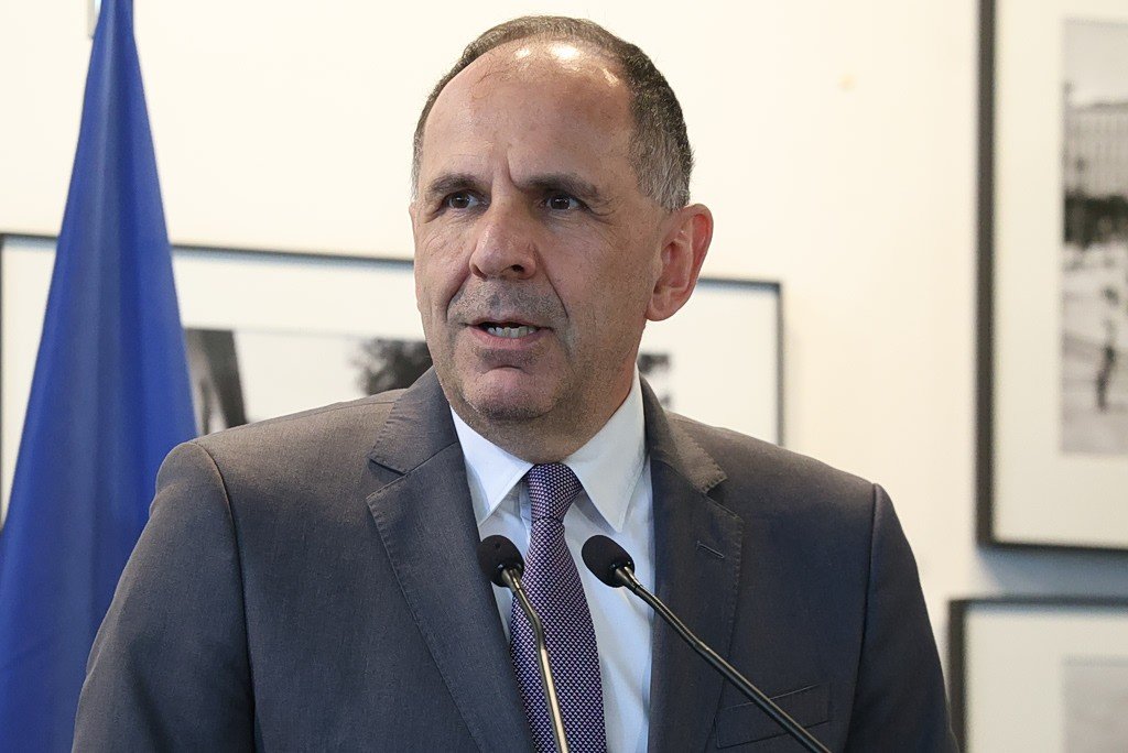 Министр иностранных дел Греции Йоргос Герапетритис выступает на пресс-конференции у микрофонов. Фото: Ta Nea