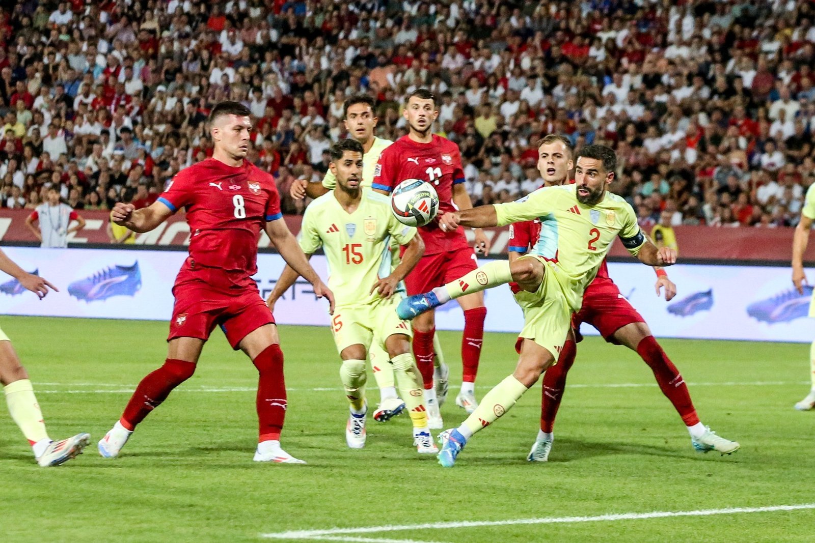 Футболисты сборных Испании и Сербии ведут борьбу за мяч в штрафной площадке во время товарищеского матча