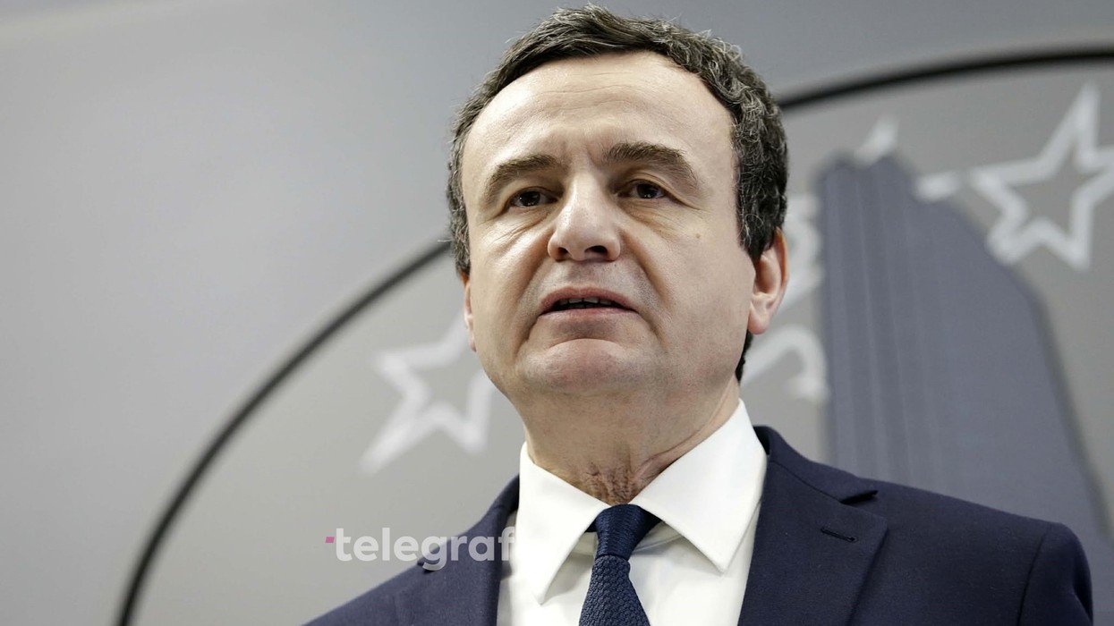 Премьер-министр Косово Албин Курти крупным планом на фоне герба Косово