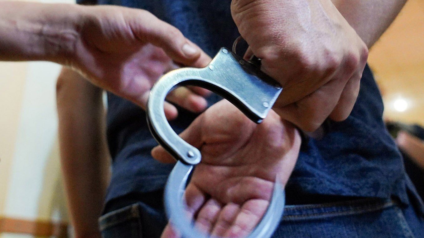 Крупный план наручников при задержании — символ приговора и лишения свободы. Фото: The Moscow Times