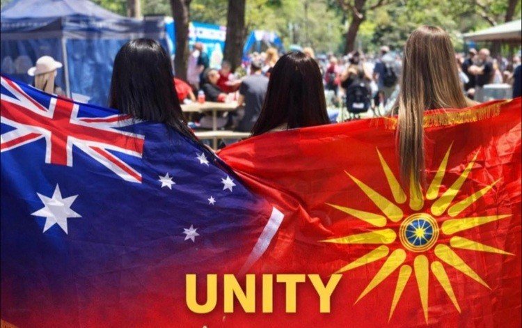 Три девушки укутаны в австралийский флаг и македонский флаг с Кутлешским солнцем на фестивале