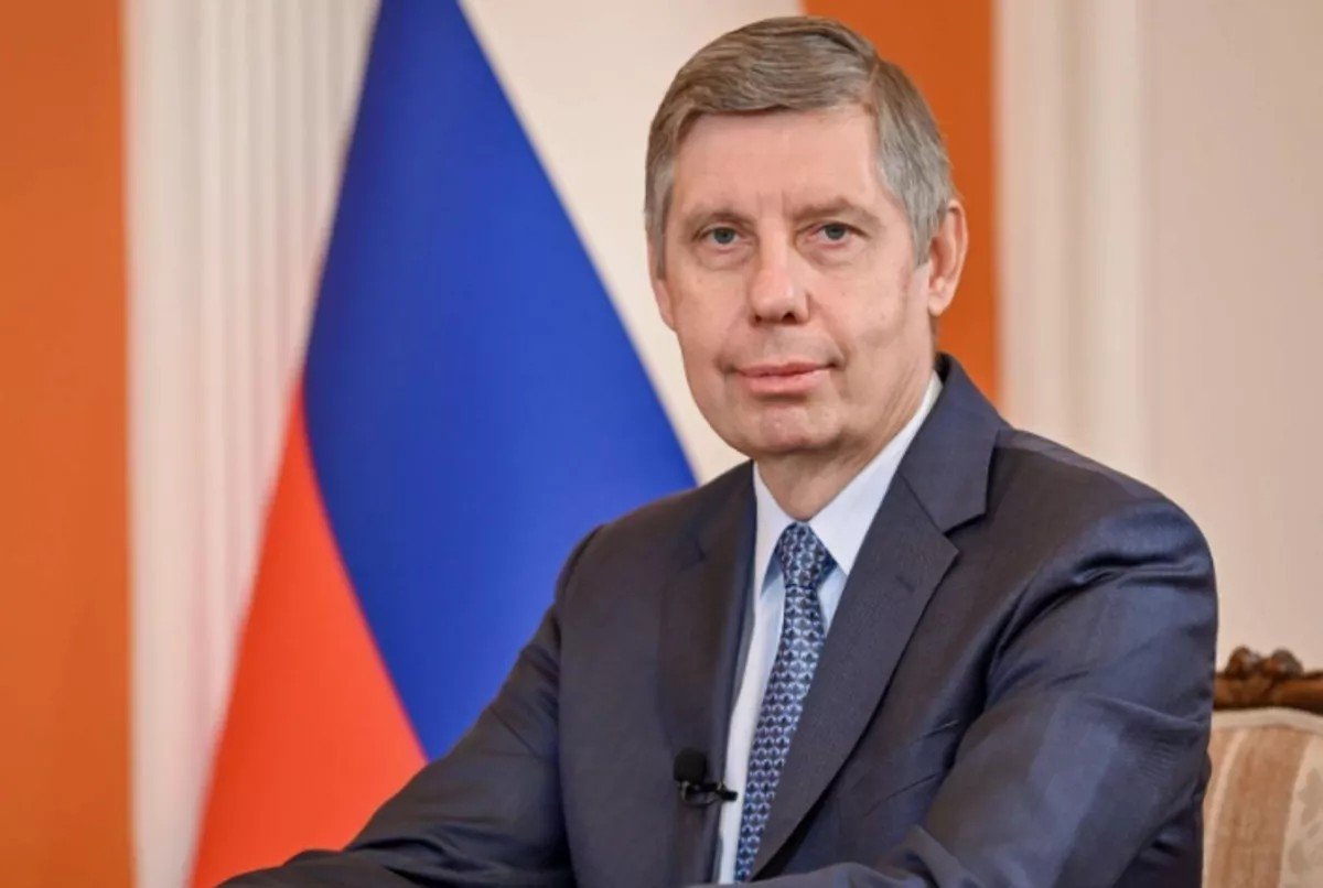 Российский дипломат на фоне государственного флага России