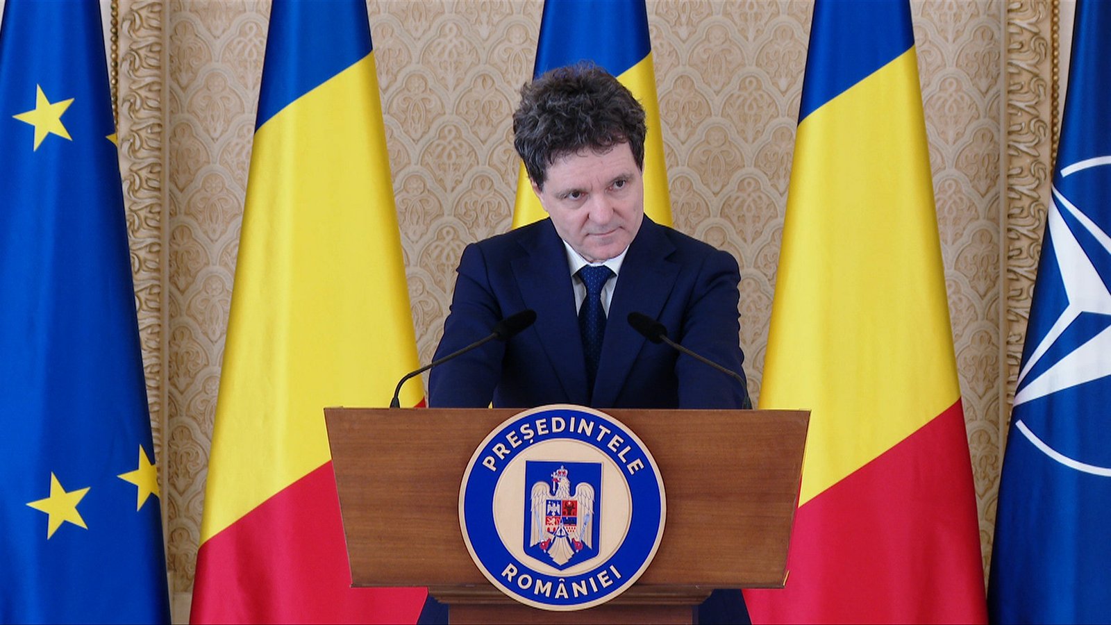 Президент Румынии Никушор Дан на пресс-конференции после заседания CSAT. На заднем плане &mdash; флаги Румынии, ЕС и НАТО
