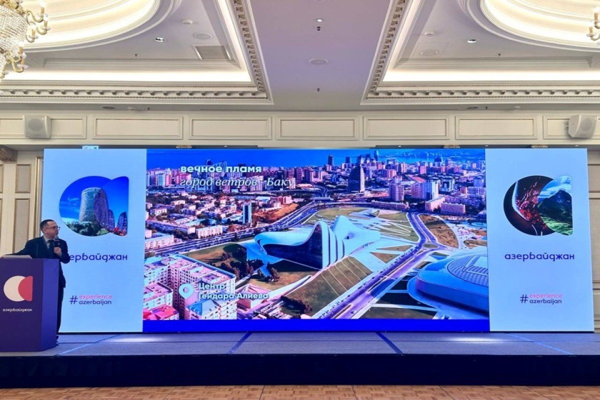 Спикер представляет достопримечательности Баку на большом экране во время туристической презентации в Москве