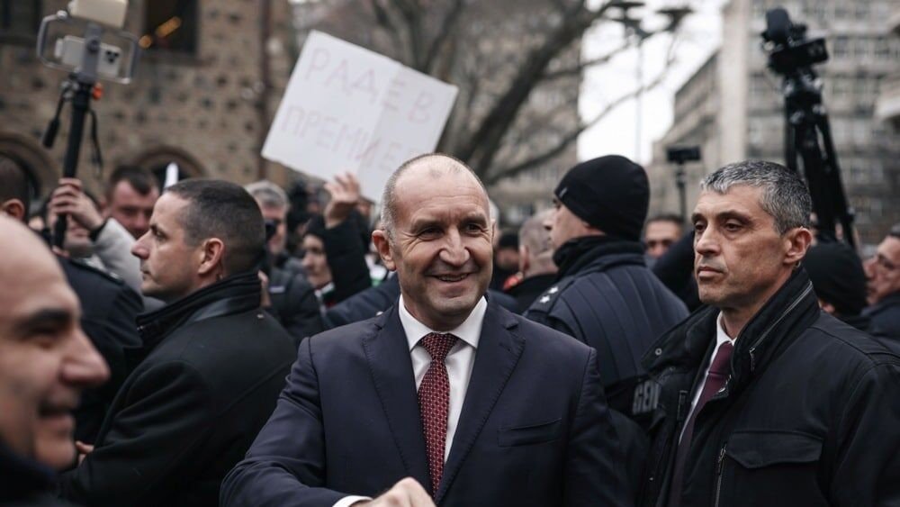 Румен Радев среди сторонников в центре Софии, над толпой видны плакаты «Радев — Премиер» и телекамеры