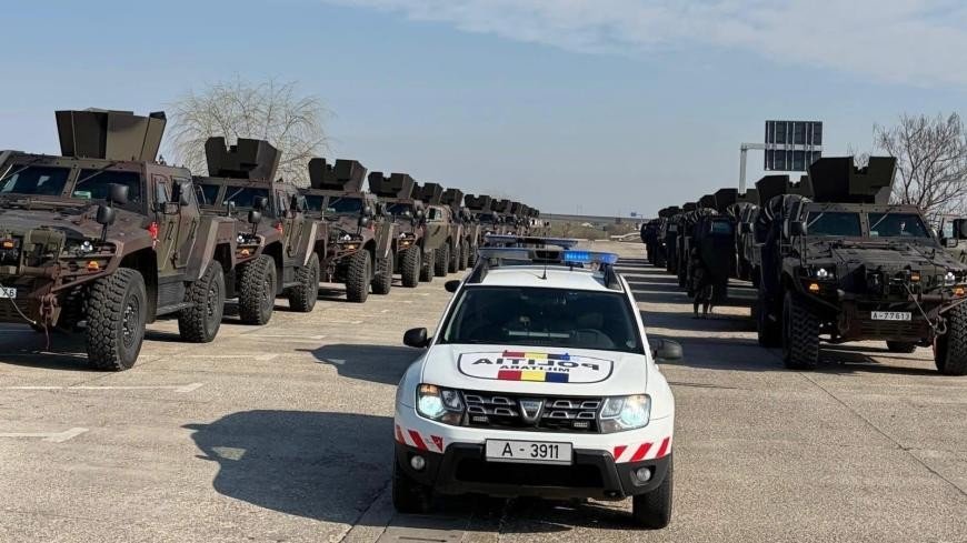 Конвой бронемашин Cobra II в сопровождении военной полиции на площадке для транспортировки в Румынии