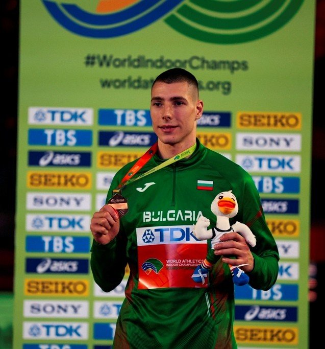 Божидар Сарабоюков с бронзовой медалью на подиуме чемпионата мира по лёгкой атлетике в помещении в Торуне