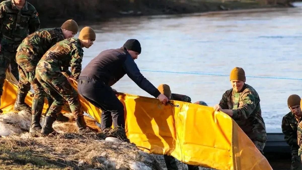 Военнослужащие устанавливают жёлтый нефтезащитный барьер на берегу Днестра