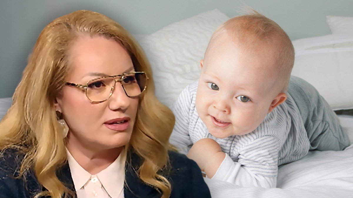 Женщина в очках рядом с улыбающимся младенцем на кровати