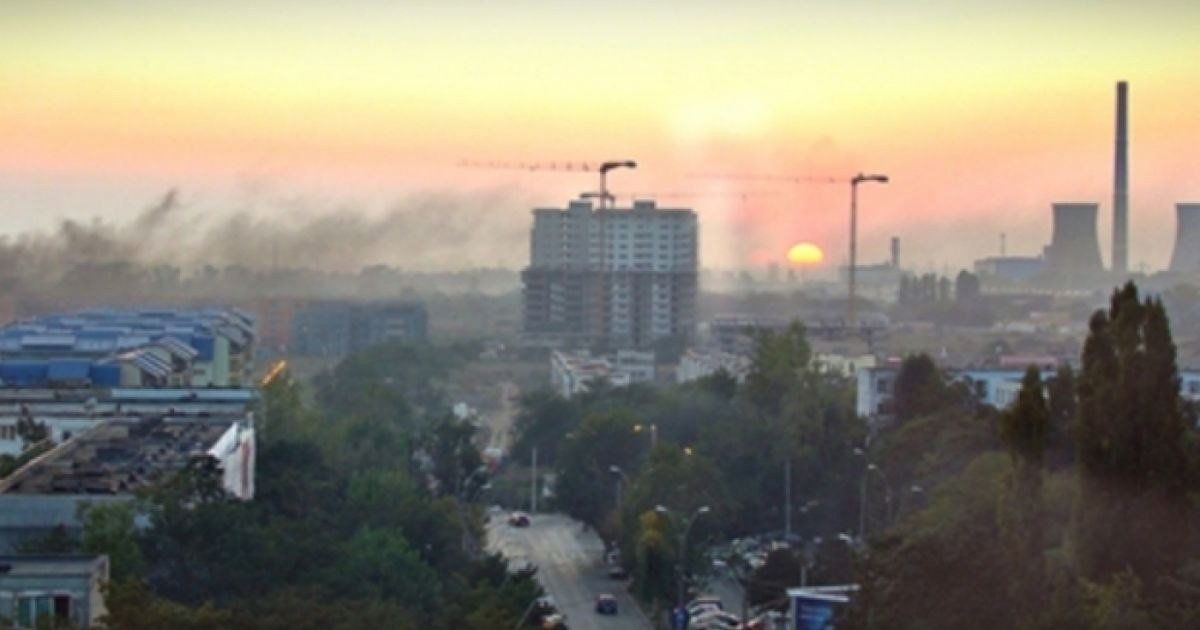 Промышленная зона Бухареста на закате -- дымовые трубы и смог над городскими кварталами