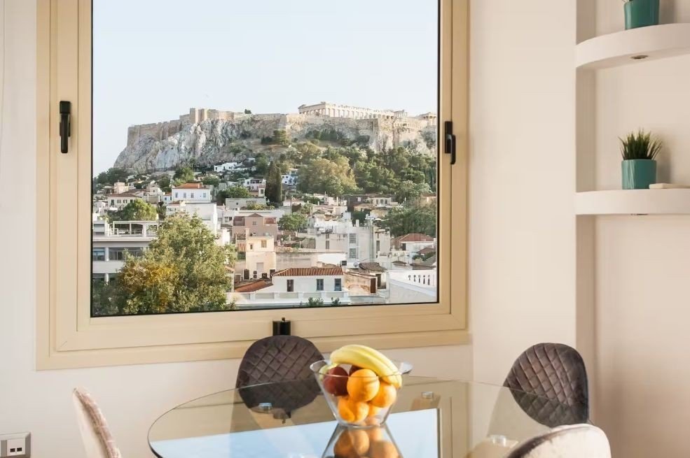 Интерьер квартиры краткосрочной аренды в Афинах с видом на Акрополь — символ превращения жилого фонда в туристический продукт
